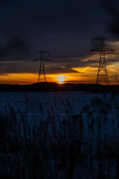 Turuncu günbatımında elektrik direkleri