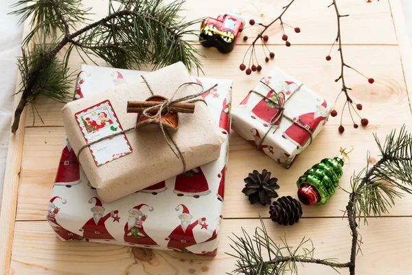 Yeni yıl hediye paketleme el yapımı çam kozalakları, Çamın dalları ve Noel süslemeleri doğal ahşap arka plan üzerinde bir arka plan üzerine tarçın çubuğu ile
