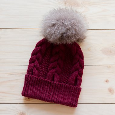 Mavi kapak yün el ile Kutup tilkisi doğal ahşap arka plan üzerinde bir kürk ponpon ile bağlı.