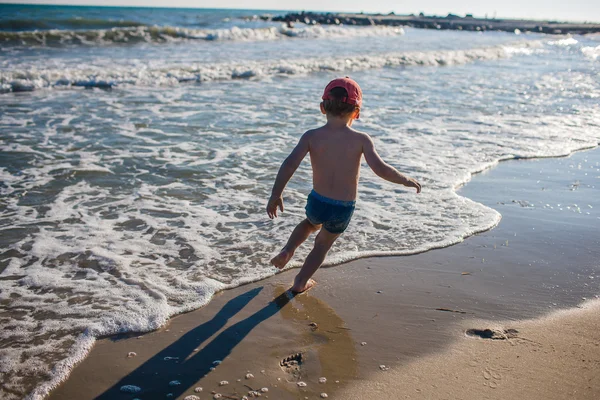 Niño jugando en la orilla del mar — Foto de Stock
