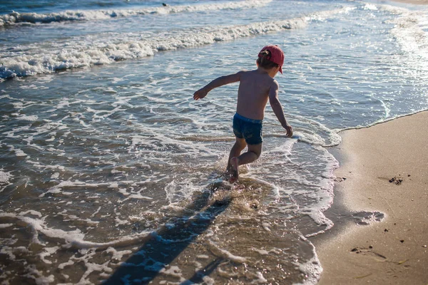 Deniz kıyısında oynayan küçük çocuk