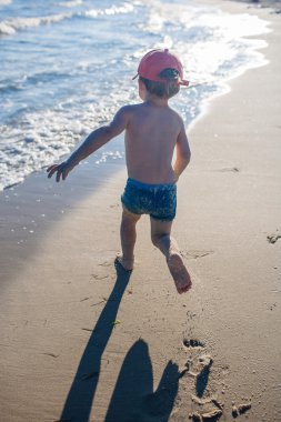 Deniz kıyısında oynayan küçük çocuk