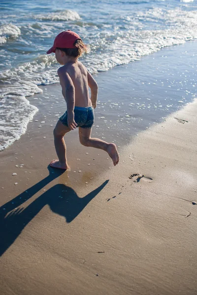 Deniz kıyısında oynayan küçük çocuk
