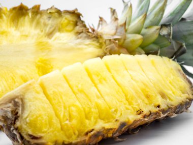 Yarım dilimlenmiş ananas ve beyaz üzerine ananas parçaları.