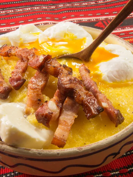 Polenta bulz con pancetta fritta e uova e cucchiaio di legno — Foto Stock