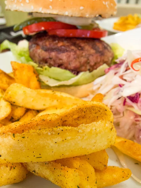 Hamburguesa de carne con papas fritas y repollo crudo en rodajas — Foto de Stock