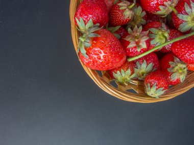 siyah arka plan üzerine bir sepet içinde taze kırmızı çilek üzerinde Üstten Görünüm