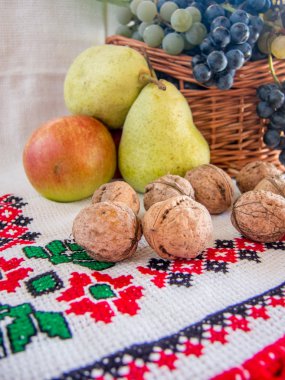 autumn harvest of grapes walnuts pears and apples on a traditional romanian towel