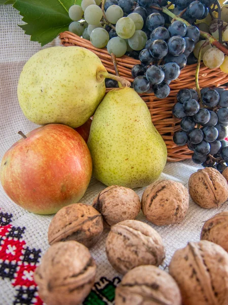 autumn harvest  of grapes walnuts pears and apples on a traditional romanian towel