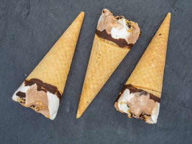 Siyah tahta üzerine dizilmiş mini dondurma külahları.