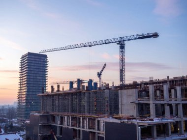 İnşaat ve metal iskelesi altında güçlendirilmiş beton yapıya sahip inşaat sahası ve dikey biçimlendirme ve inşaat alanında işçiler