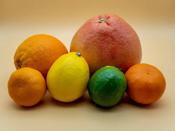 Turuncu arka planda çeşitli turunçgil meyveleri