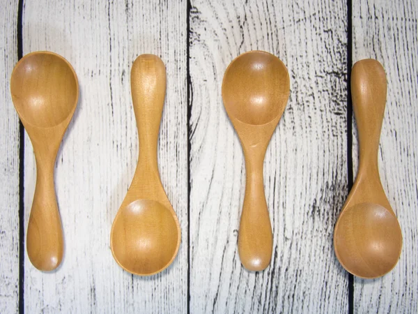 Four wooden teaspoons on wooden table — Stock Photo, Image