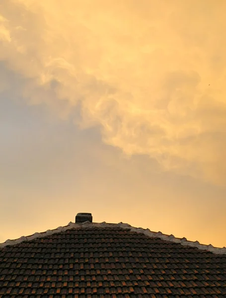 Ominoso cielo naranja reflejo en el techo —  Fotos de Stock