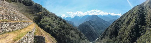 İnka Patikası 'nın panoramik manzarası vadinin aşağısındaki vadilerle dolu, bir sürü bitki örtüsü olan yüksek dağlar ve Machu Pichu yolu.
