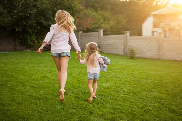 Back view of mother and daughter running in the garden — Stock Photo, Image