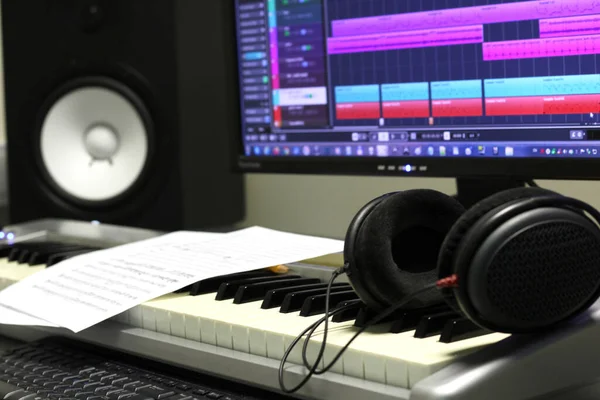 Music production interior with score keyboard, speaker and headphones