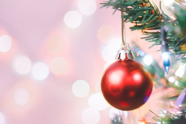 Noel süsü. Çam dallarında asılı kırmızı toplar Noel ağacı çelengi ve soyut bokeh arka planında fotokopi ile süslenmiş süsler.