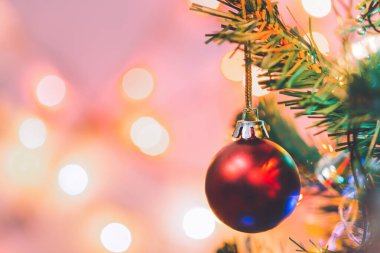 Noel süsü. Çam dallarında asılı kırmızı toplar Noel ağacı çelengi ve soyut bokeh arka planında fotokopi ile süslenmiş süsler.