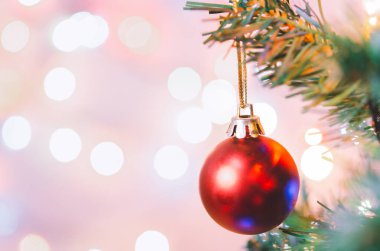 Noel süsü. Çam dallarında asılı kırmızı toplar Noel ağacı çelengi ve soyut bokeh arka planında fotokopi ile süslenmiş süsler.