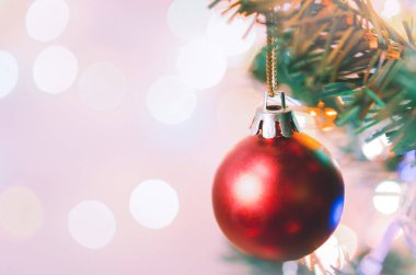 Noel süsü. Çam dallarında asılı kırmızı toplar Noel ağacı çelengi ve soyut bokeh arka planında fotokopi ile süslenmiş süsler.