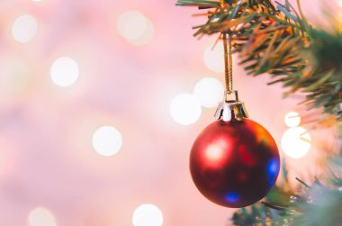 Noel süsü. Çam dallarında asılı kırmızı toplar Noel ağacı çelengi ve soyut bokeh arka planında fotokopi ile süslenmiş süsler.