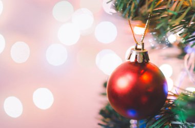 Noel süsü. Çam dallarında asılı kırmızı toplar Noel ağacı çelengi ve soyut bokeh arka planında fotokopi ile süslenmiş süsler.