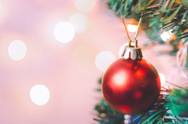 Noel süsü. Çam dallarında asılı kırmızı toplar Noel ağacı çelengi ve soyut bokeh arka planında fotokopi ile süslenmiş süsler.