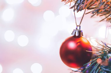 Noel süsü. Çam dallarında asılı kırmızı toplar Noel ağacı çelengi ve soyut bokeh arka planında fotokopi ile süslenmiş süsler.