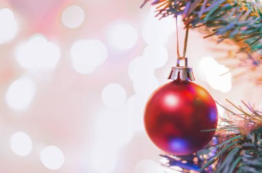 Noel süsü. Çam dallarında asılı kırmızı toplar Noel ağacı çelengi ve soyut bokeh arka planında fotokopi ile süslenmiş süsler.