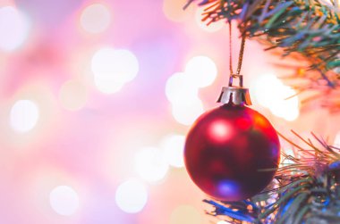 Noel süsü. Çam dallarında asılı kırmızı toplar Noel ağacı çelengi ve soyut bokeh arka planında fotokopi ile süslenmiş süsler.