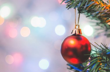 Noel süsü. Çam dallarında asılı kırmızı toplar Noel ağacı çelengi ve soyut bokeh arka planında fotokopi ile süslenmiş süsler.