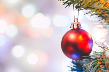 Noel süsü. Çam dallarında asılı kırmızı toplar Noel ağacı çelengi ve soyut bokeh arka planında fotokopi ile süslenmiş süsler.