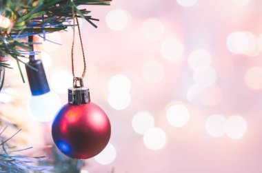 Noel süsü. Çam dallarında asılı kırmızı toplar Noel ağacı çelengi ve soyut bokeh arka planında fotokopi ile süslenmiş süsler.