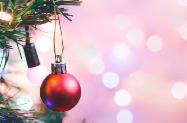Noel süsü. Çam dallarında asılı kırmızı toplar Noel ağacı çelengi ve soyut bokeh arka planında fotokopi ile süslenmiş süsler.