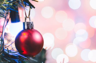 Noel süsü. Çam dallarında asılı kırmızı toplar Noel ağacı çelengi ve soyut bokeh arka planında fotokopi ile süslenmiş süsler.