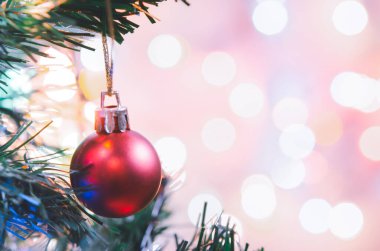 Noel süsü. Çam dallarında asılı kırmızı toplar Noel ağacı çelengi ve soyut bokeh arka planında fotokopi ile süslenmiş süsler.