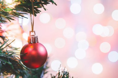 Noel süsü. Çam dallarında asılı kırmızı toplar Noel ağacı çelengi ve soyut bokeh arka planında fotokopi ile süslenmiş süsler.