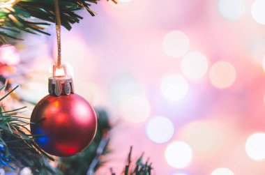 Noel süsü. Çam dallarında asılı kırmızı toplar Noel ağacı çelengi ve soyut bokeh arka planında fotokopi ile süslenmiş süsler.