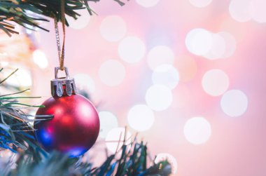 Noel süsü. Çam dallarında asılı kırmızı toplar Noel ağacı çelengi ve soyut bokeh arka planında fotokopi ile süslenmiş süsler.