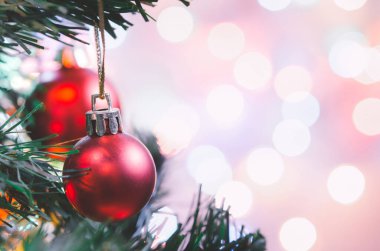 Noel süsü. Çam dallarında asılı kırmızı toplar Noel ağacı çelengi ve soyut bokeh arka planında fotokopi ile süslenmiş süsler.