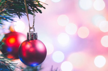 Noel süsü. Çam dallarında asılı kırmızı toplar Noel ağacı çelengi ve soyut bokeh arka planında fotokopi ile süslenmiş süsler.