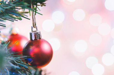 Noel süsü. Çam dallarında asılı kırmızı toplar Noel ağacı çelengi ve soyut bokeh arka planında fotokopi ile süslenmiş süsler.