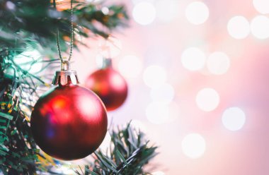 Noel süsü. Çam dallarında asılı kırmızı toplar Noel ağacı çelengi ve soyut bokeh arka planında fotokopi ile süslenmiş süsler.