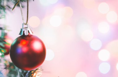 Noel süsü. Çam dallarında asılı kırmızı toplar Noel ağacı çelengi ve soyut bokeh arka planında fotokopi ile süslenmiş süsler.