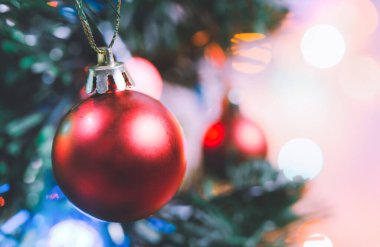Noel süsü. Çam dallarında asılı kırmızı toplar Noel ağacı çelengi ve soyut bokeh arka planında fotokopi ile süslenmiş süsler.