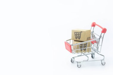 Alışveriş konsepti - beyaz arka planda kırmızı alışveriş arabasında karton veya karton kutular. Çevrimiçi alışveriş tüketicileri evden ve teslimat servisinden alışveriş yapabilirler. Kopyalama çubuğuyla