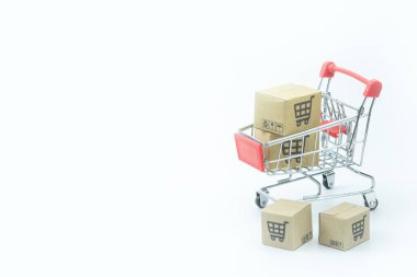 Alışveriş konsepti - beyaz arka planda kırmızı alışveriş arabasında karton veya karton kutular. Çevrimiçi alışveriş tüketicileri evden ve teslimat servisinden alışveriş yapabilirler. Kopyalama çubuğuyla