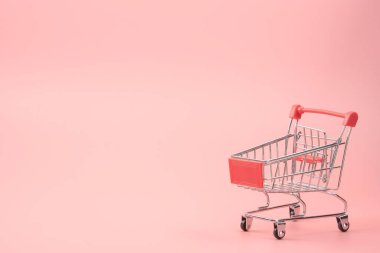 Alışveriş konsepti - Pembe arka planda kırmızı alışveriş arabası