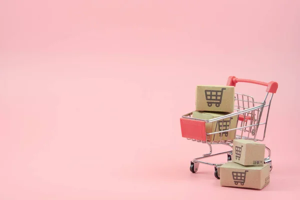 카트에 상자나 상자를 분홍색 배경으로 온라인 소비자들은 서비스에서 쇼핑을 수있다 — 스톡 사진
